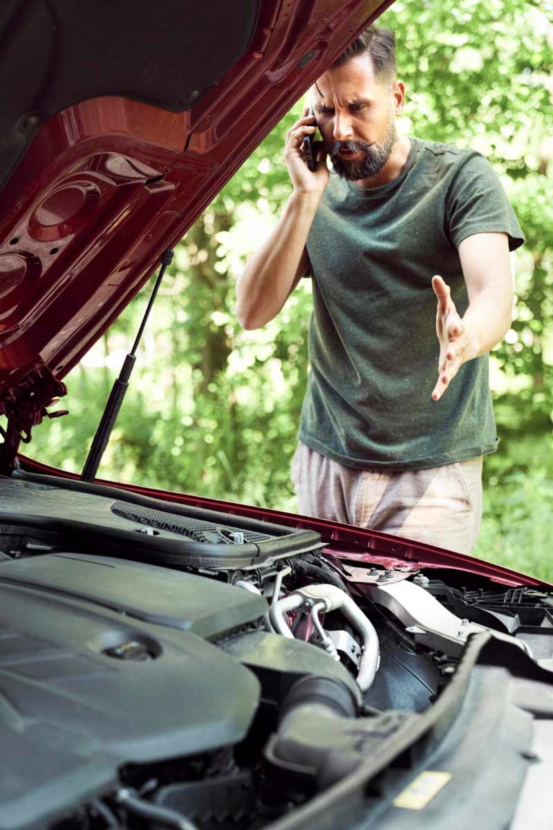Junger Mann prüft Getriebeschaden bei Schrottauto Ankauf Iserlohn
